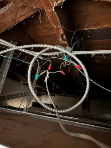 Messy ceiling wiring with wire nuts and metal conduit