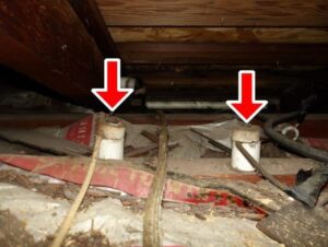 Old attic wiring supported by ceramic knobs, a classic sign of knob-and-tube wiring