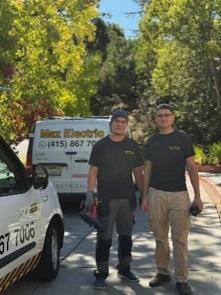 Max Electric team members standing outside with company vehicle