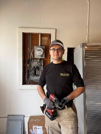 Max Electric electrician standing indoors during electrical work