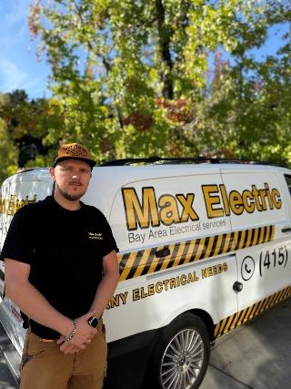 Max Electric team member standing near company branding