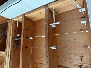 Old knob-and-tube wiring running through open wall studs with visible ceramic supports