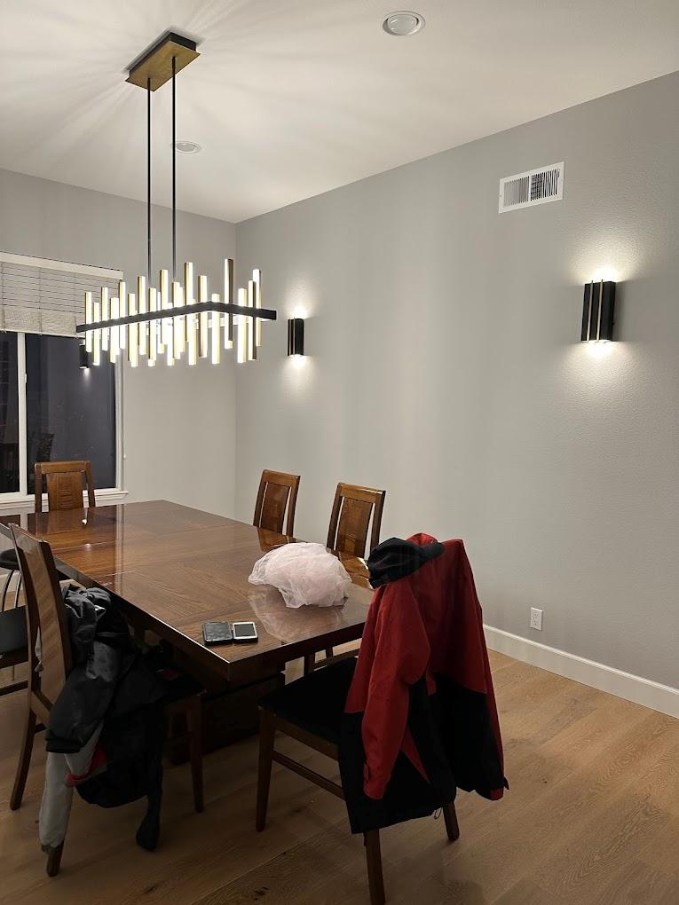 Contemporary chandelier and wall lighting installation in dining room