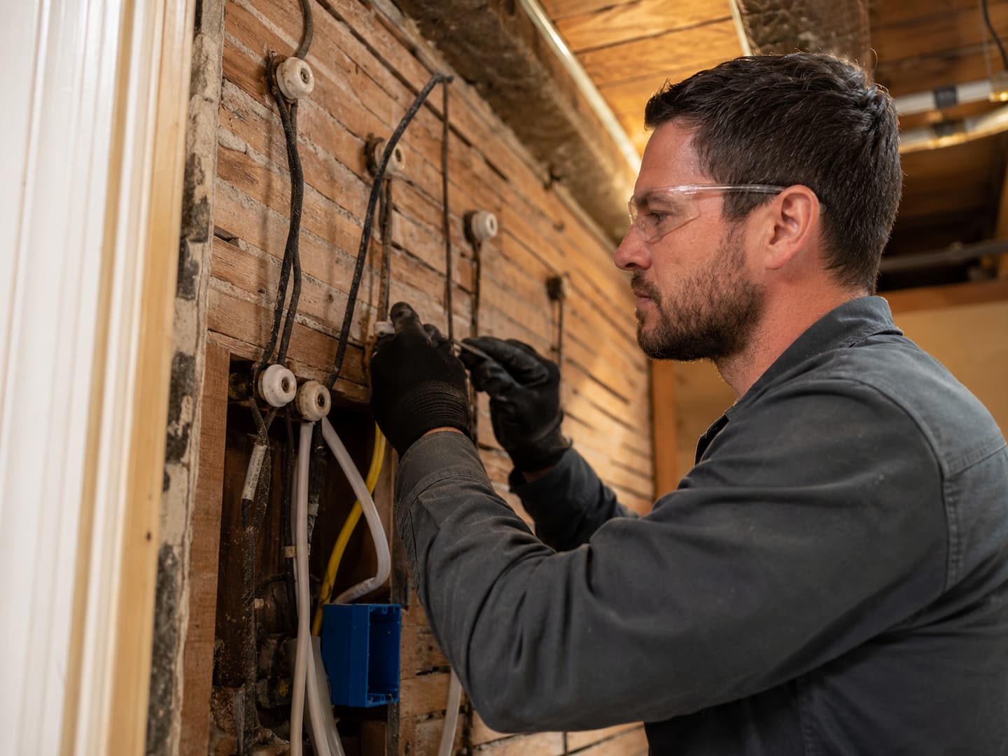 Electrician inspecting knob and tube wiring in an older San Francisco home