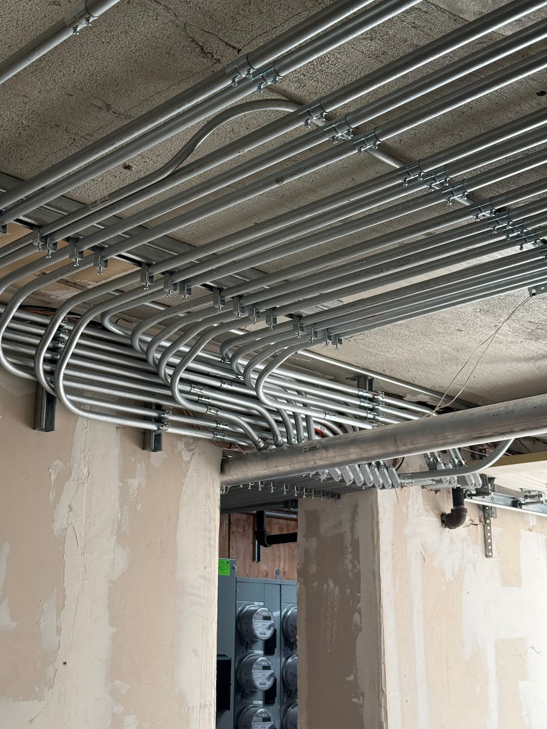 Garage entry overhead conduit installation for 16-unit building