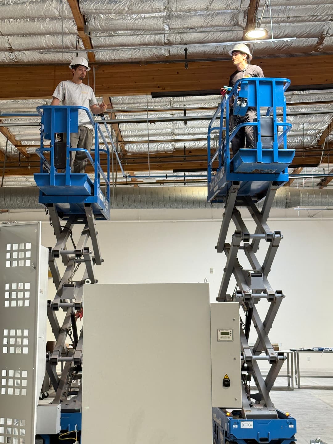 Overhead electrical conduit installation using lifts