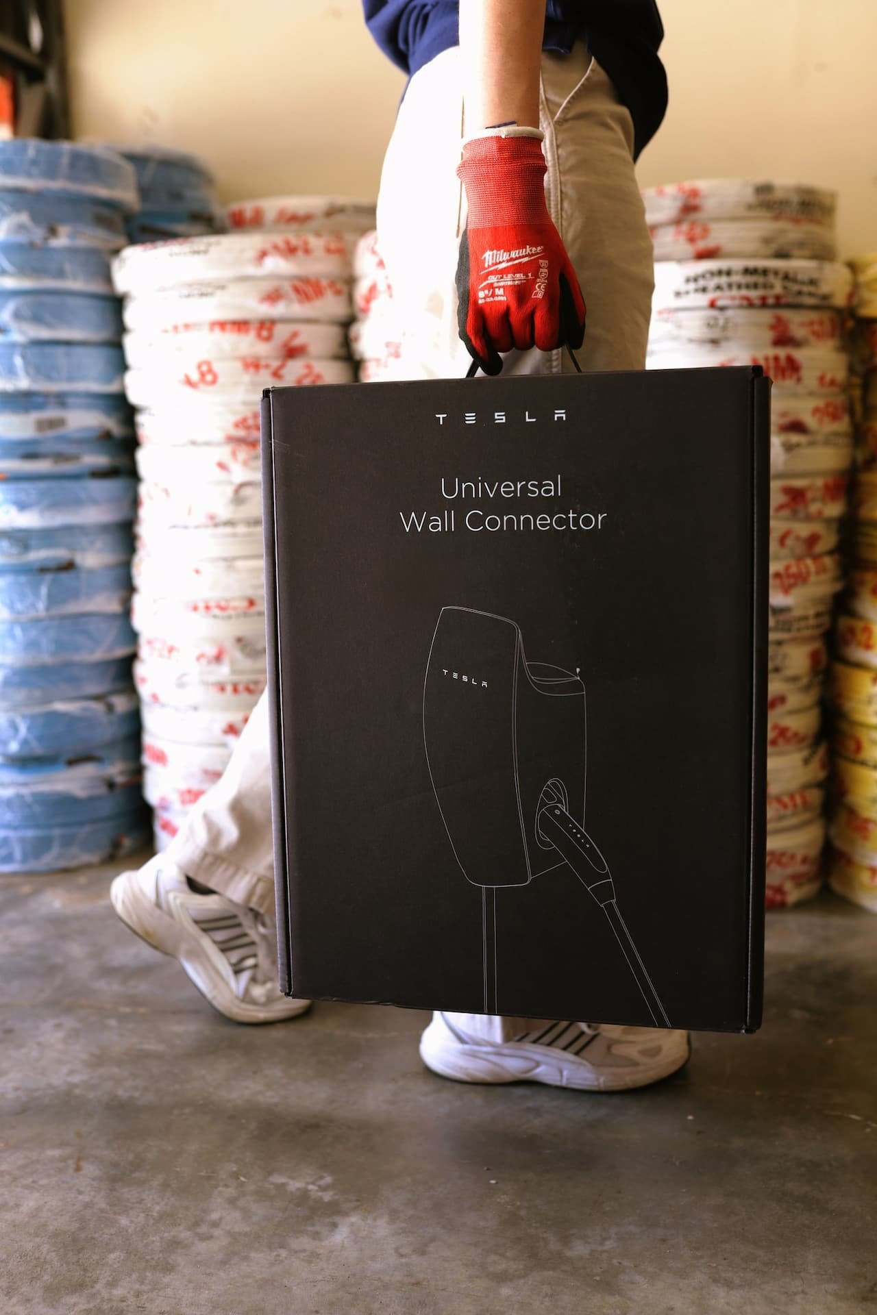 MaxElectric technician carrying a Tesla Universal Wall Connector