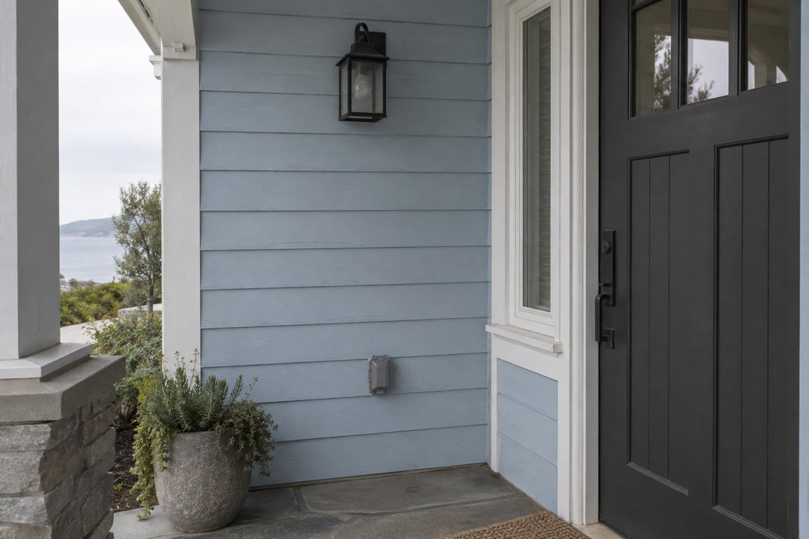 Outdoor outlet cover and wall light beside a covered entry