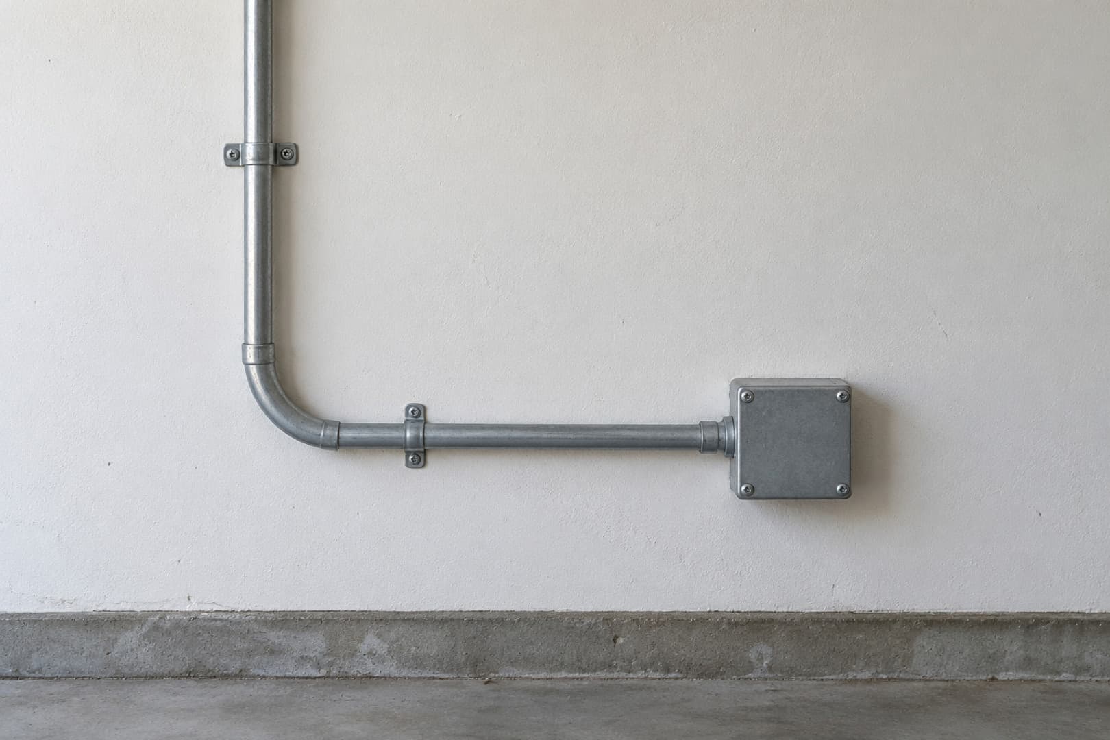 Surface conduit following a clear route along a garage wall
