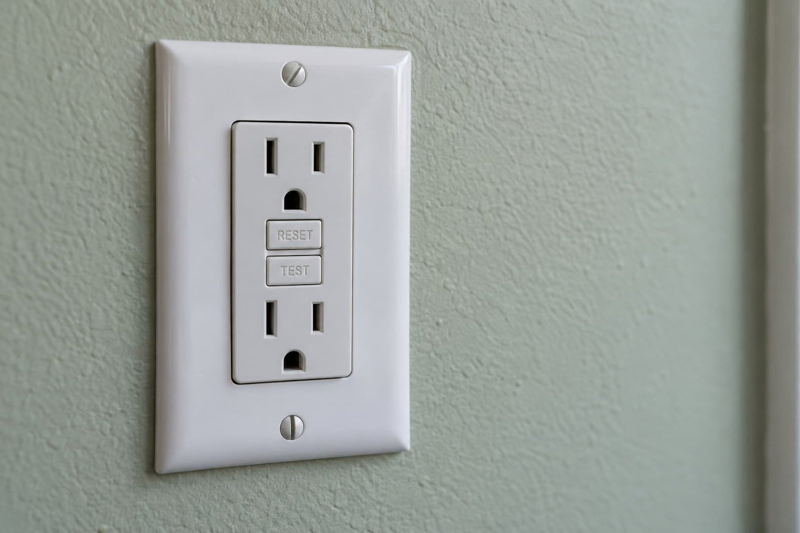 Close view of the TEST and RESET buttons on a white GFCI receptacle
